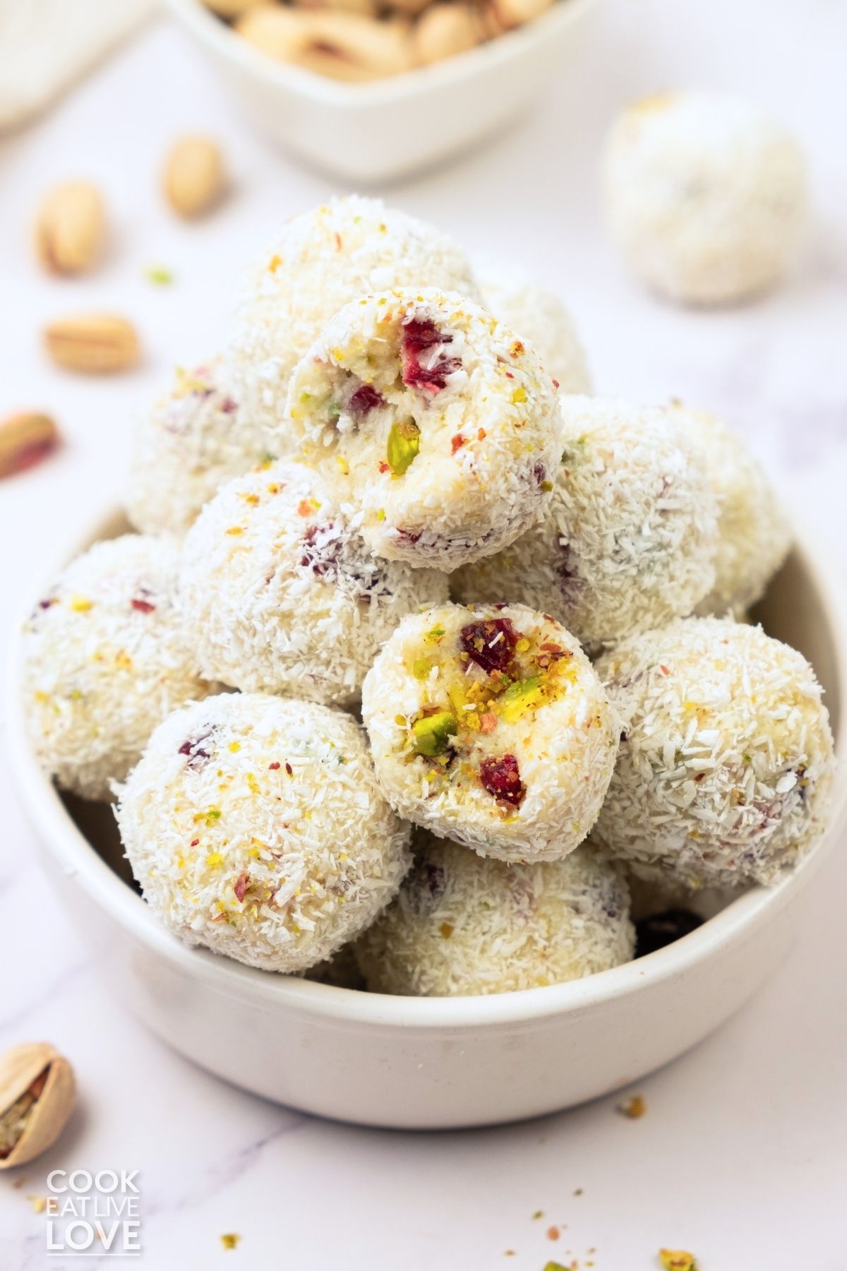 White chocolate truffles with cranberries and pistachios stacked in a bowl.