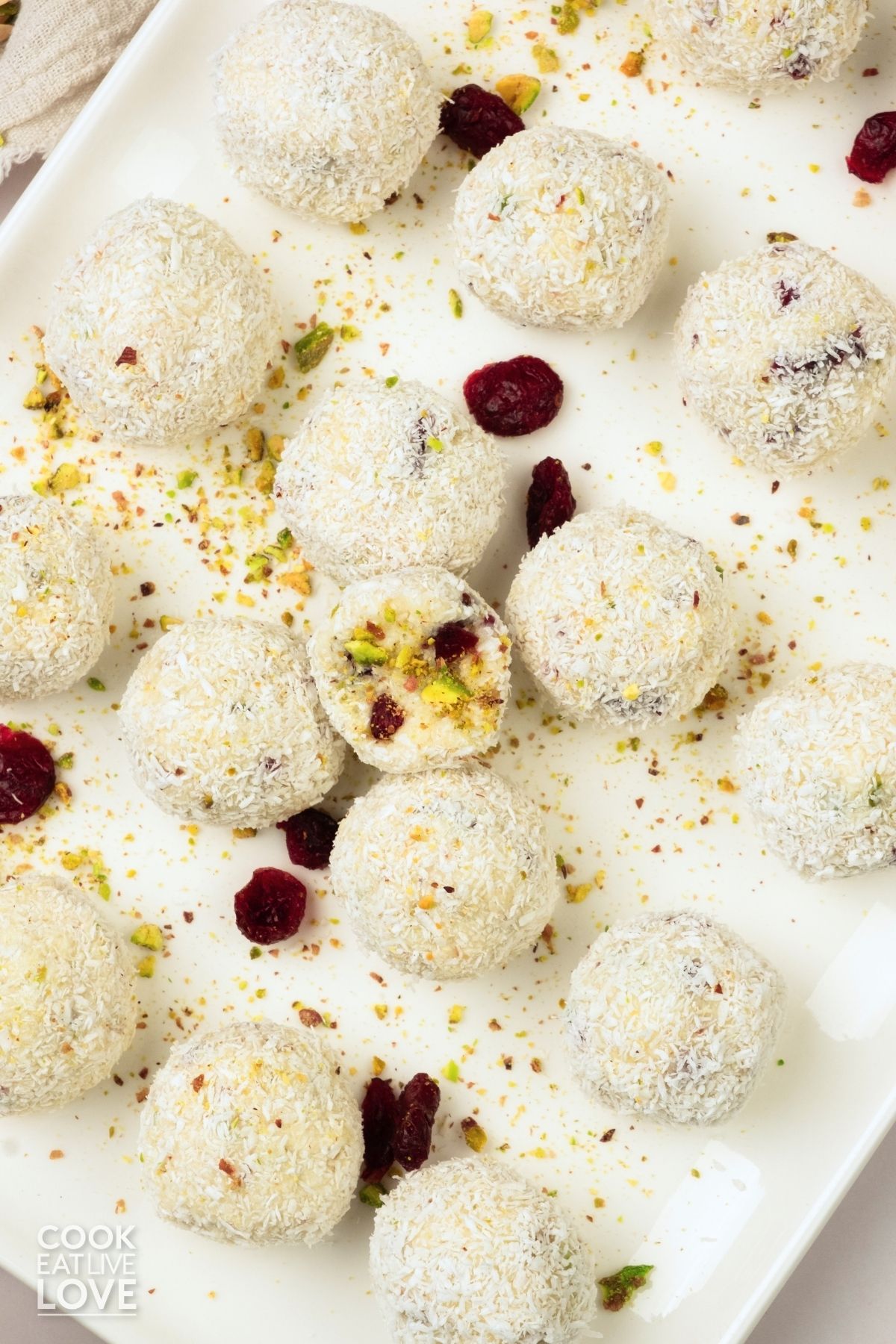 Truffles with pistachios and cranberries on a plate.