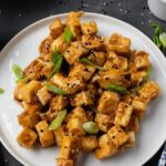 Pinterest graphic with honey garlic tofu on a plate and text on top.