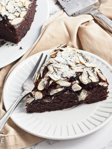 A slice of chocolate olive oil cake on a plate.