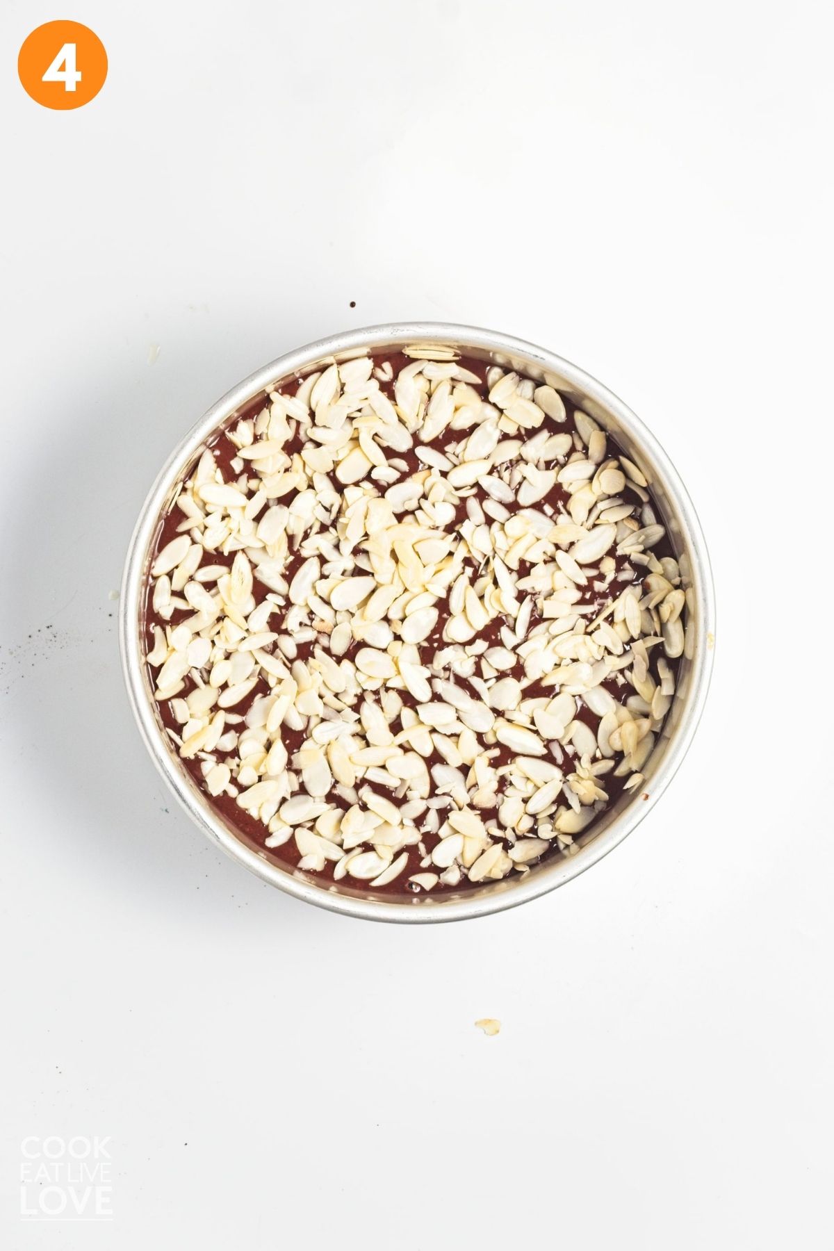 Sliced almonds put along the top of the cake in a single layer.