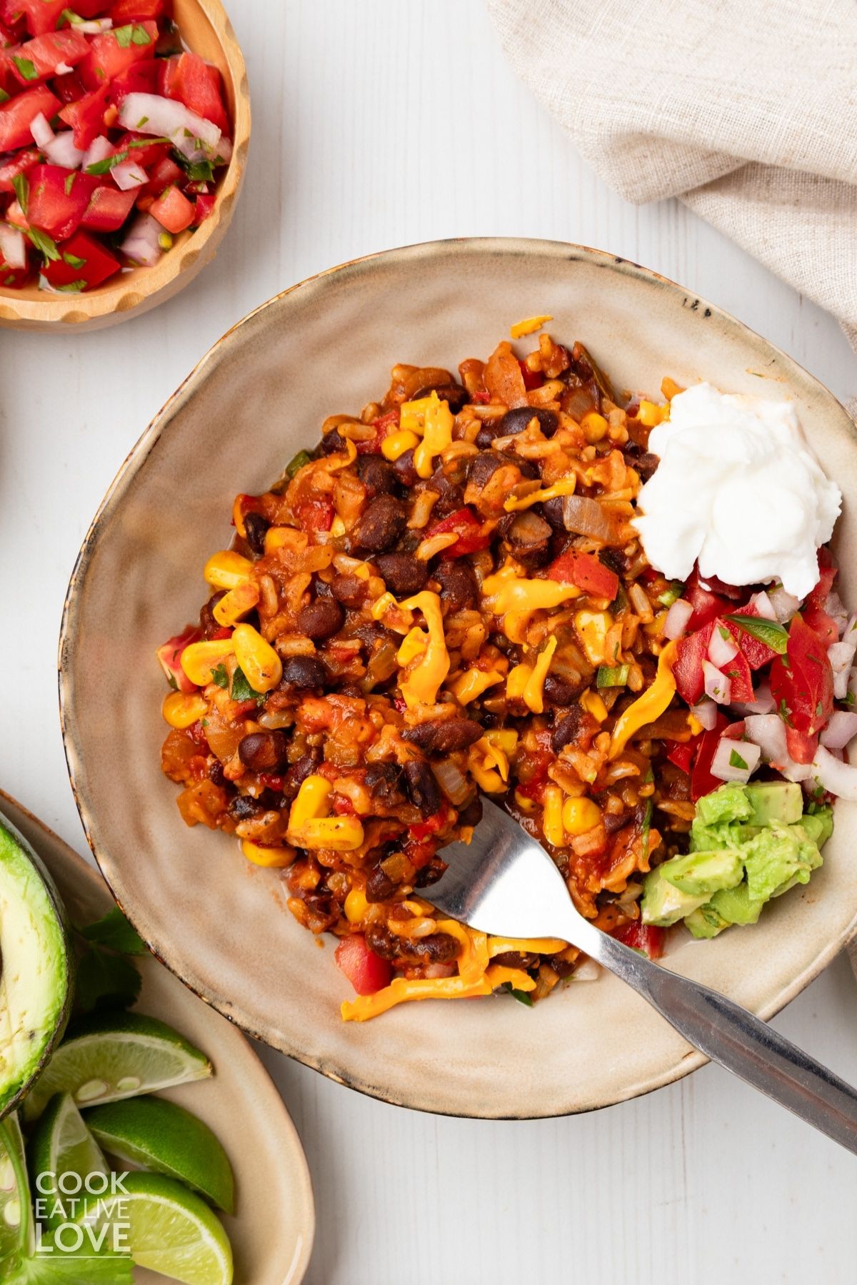A bowl filled with taco rice and a fork taking some out.