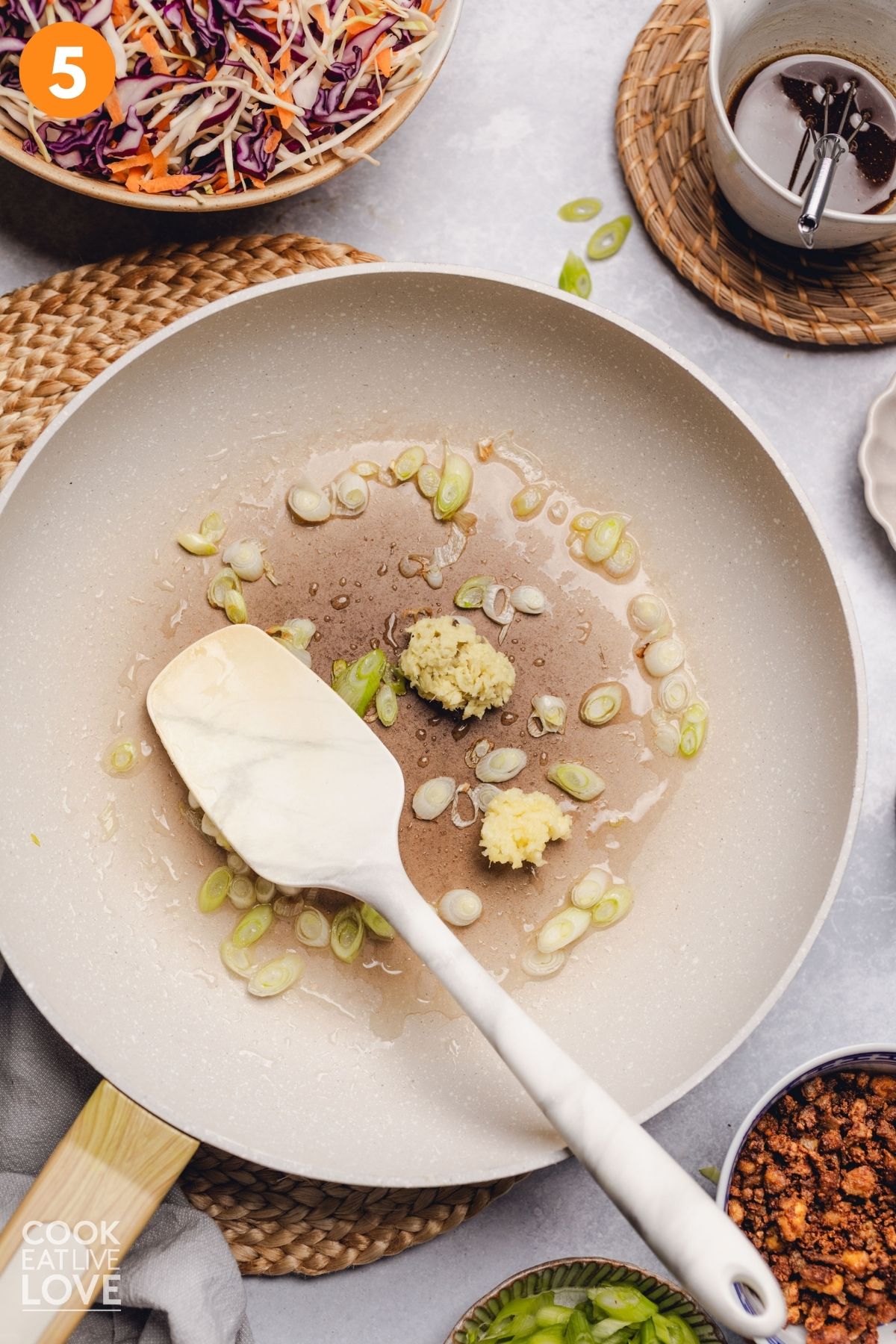 Green onions in oil in a skillet.
