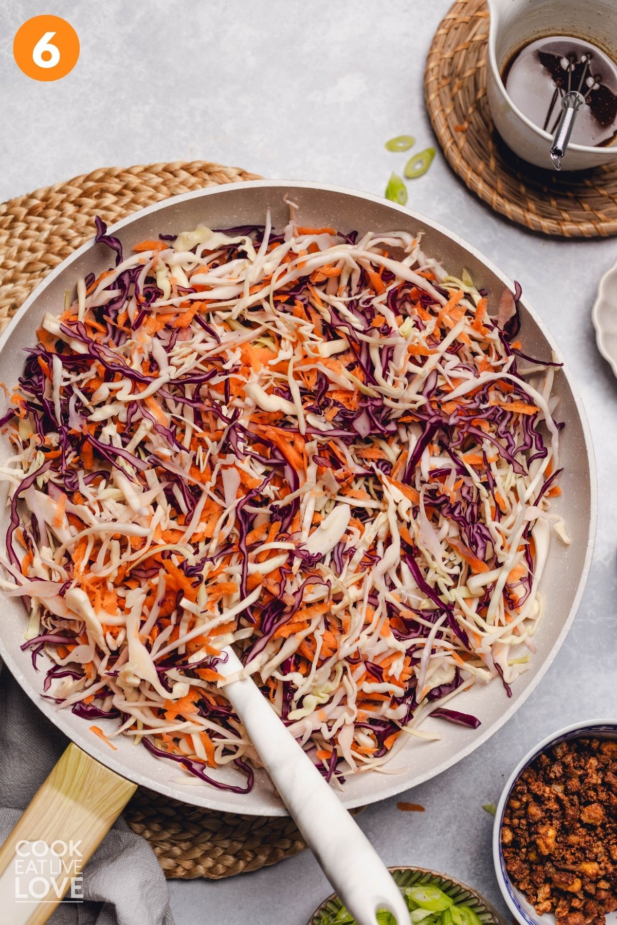 Shredded cabbage and carrots in a skillet.