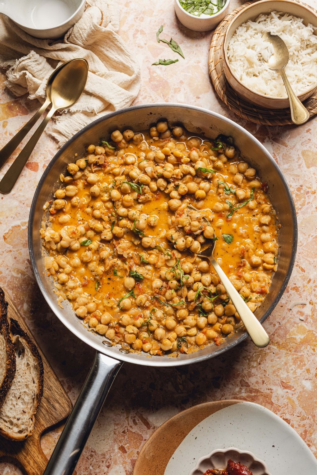 Marry me chickpeas in a skillet with a spoon resting in the pan. 
