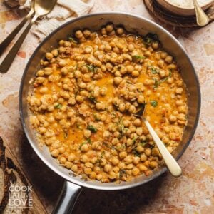 Marry me chickpeas in a skillet with a spoon resting in the dish.