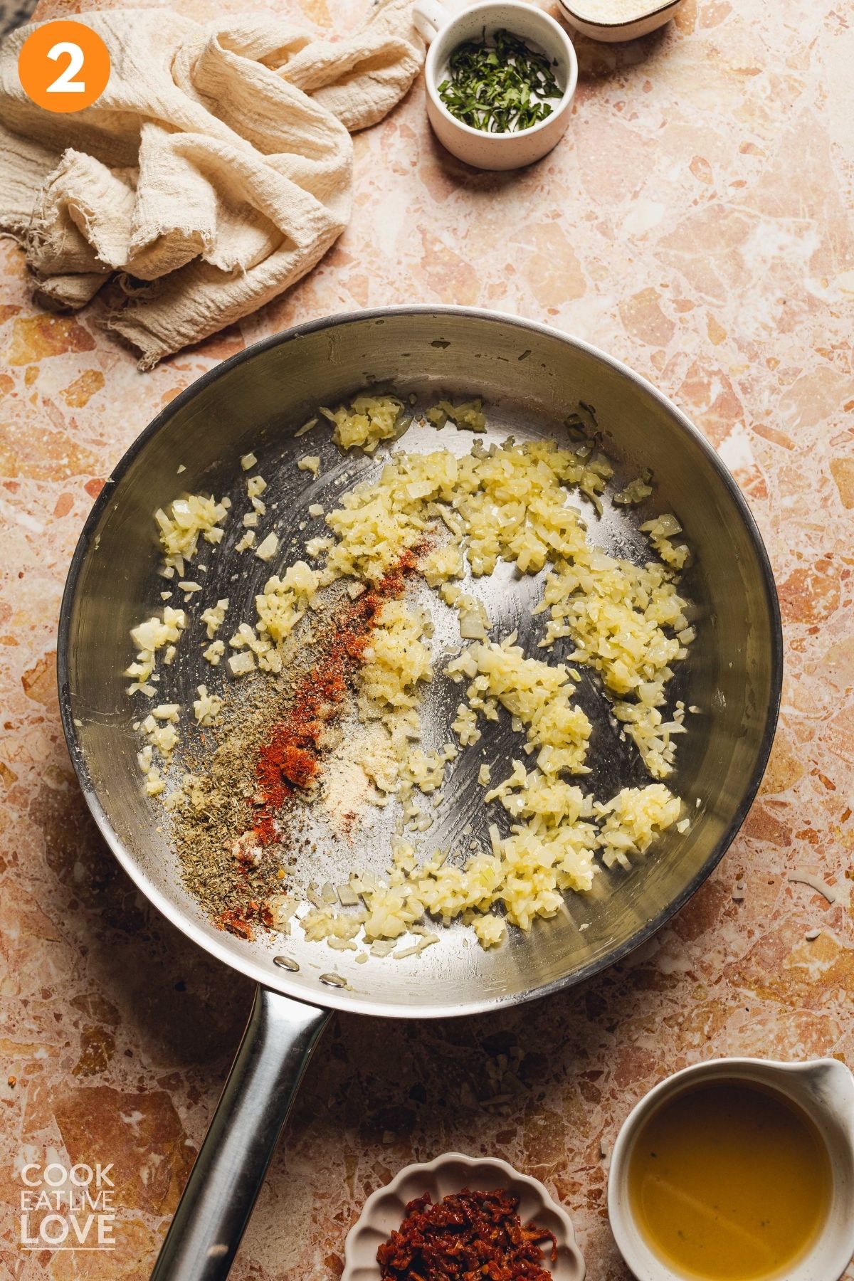 Garlic, butter, italian seasoning, paprika, pepper flakes, salt, pepper, and garlic powder added to the skillet.