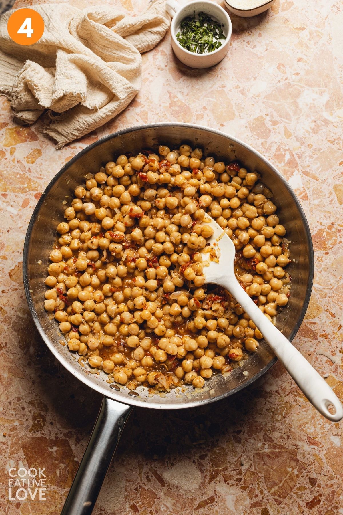 The chickpeas cooking in the skillet.