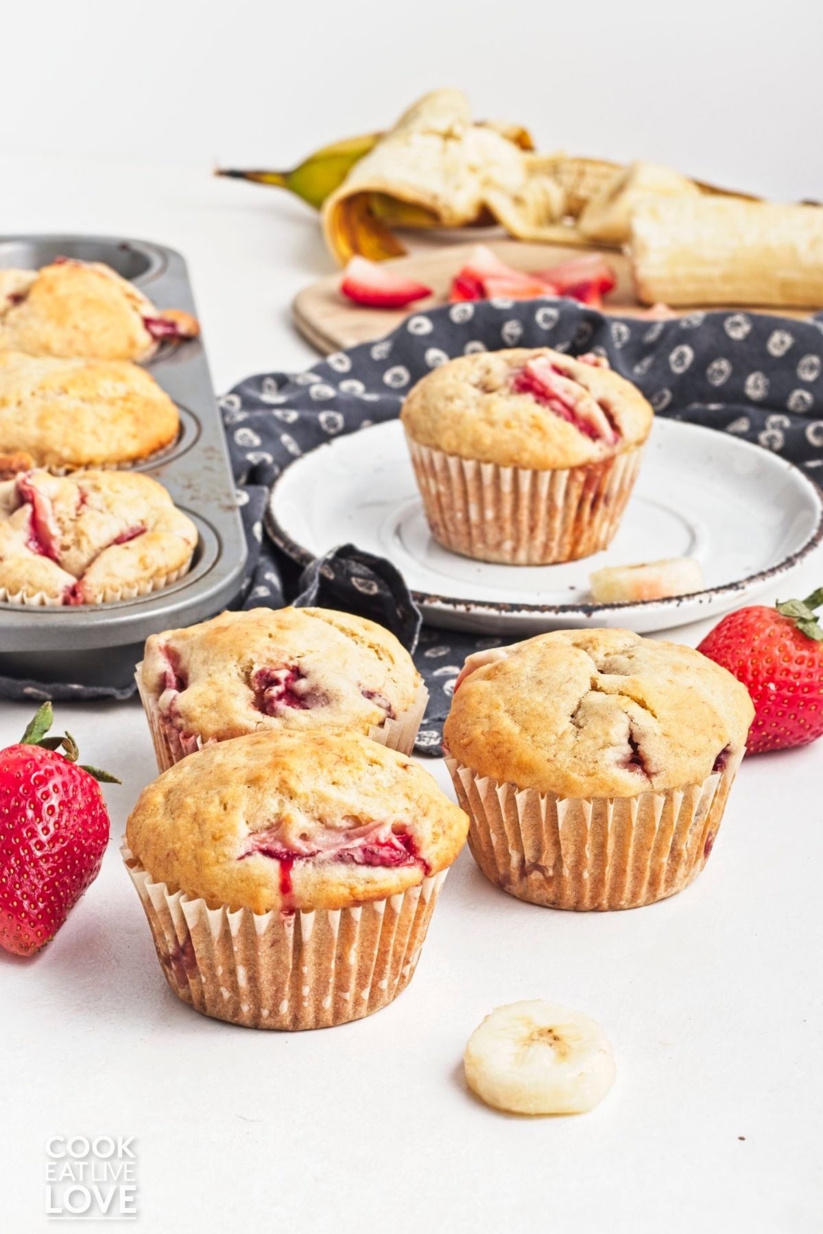 Muffins with strawberries and bananas spread all throughout the table.