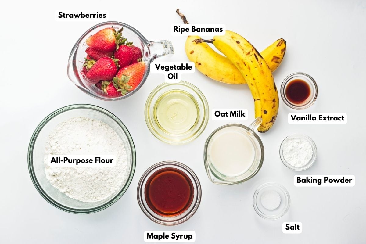 Ingredients to make these vegan strawberry muffins in bowls on a table.