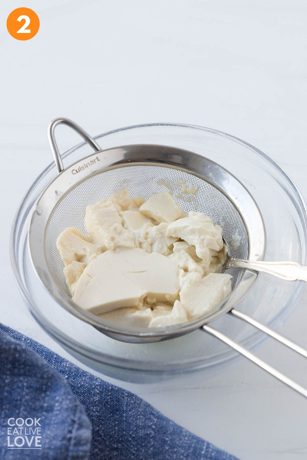 Tofu draining in a strainer. 