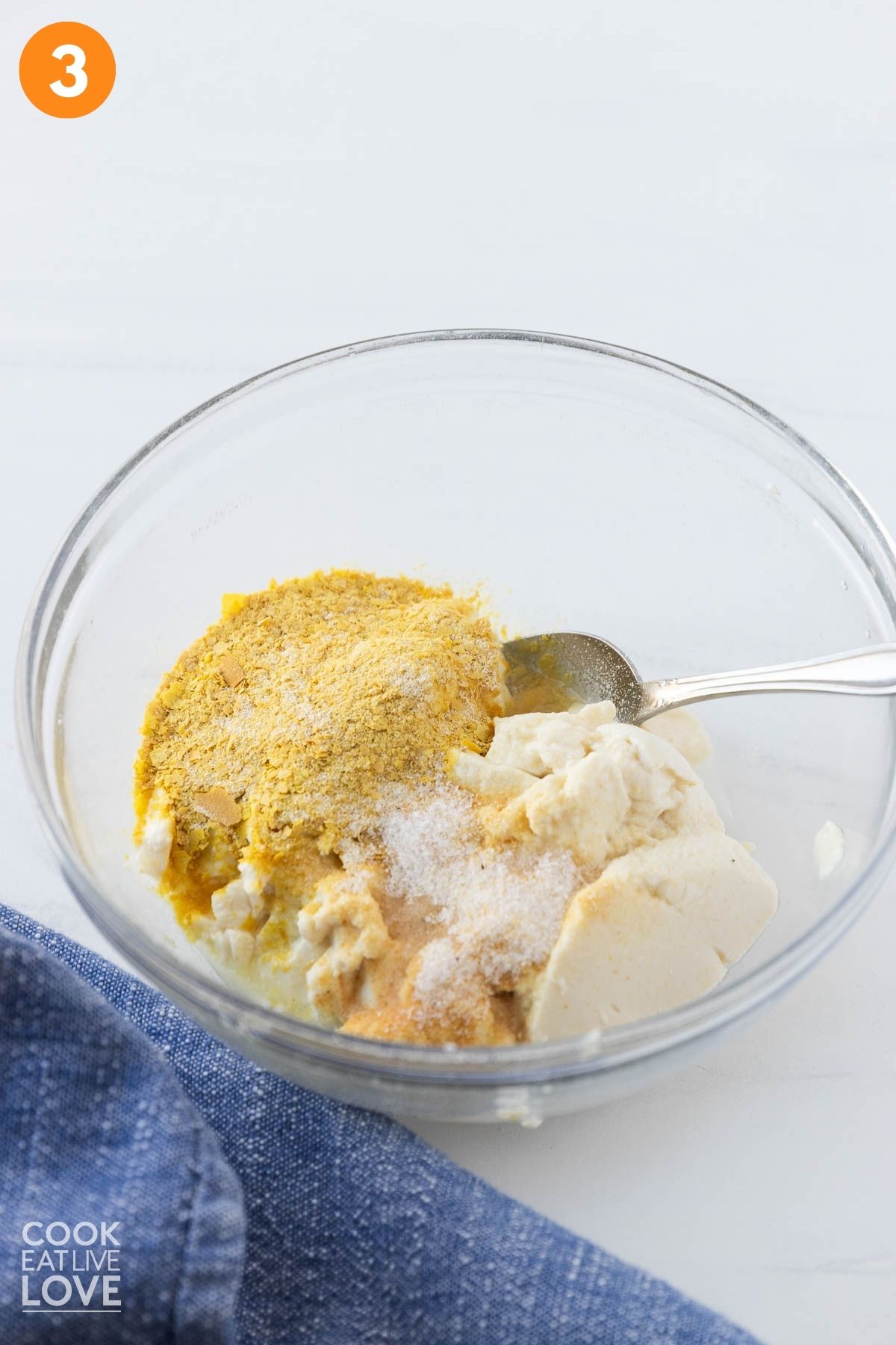 Seasonings added to the silken tofu in a bowl. 