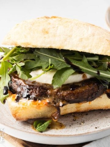 A portobello mushroom sandwich on a white plate.
