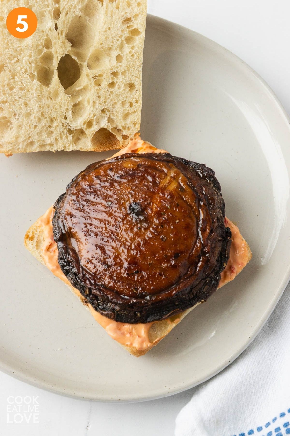 Assembling the portobello mushroom sandwich on a ciabatta roll.