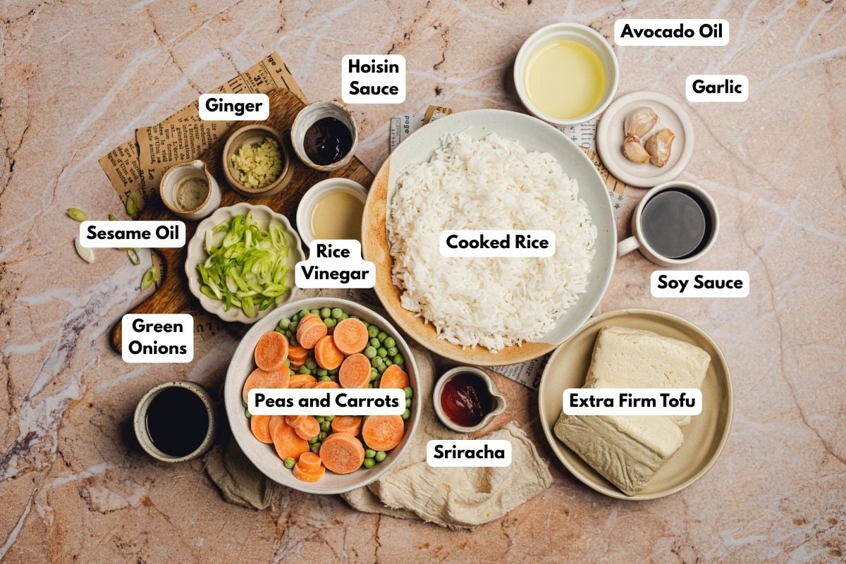 Ingredients to make this tofu fried rice in bowls on a table.