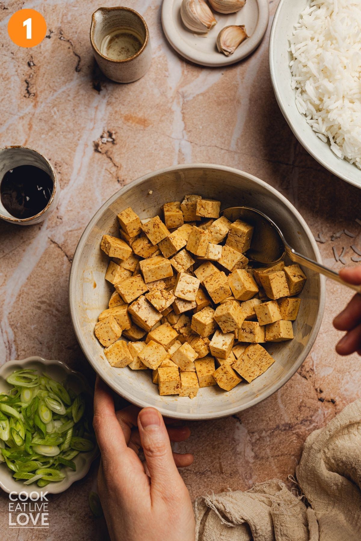 Tofu in a bowl being mixed.