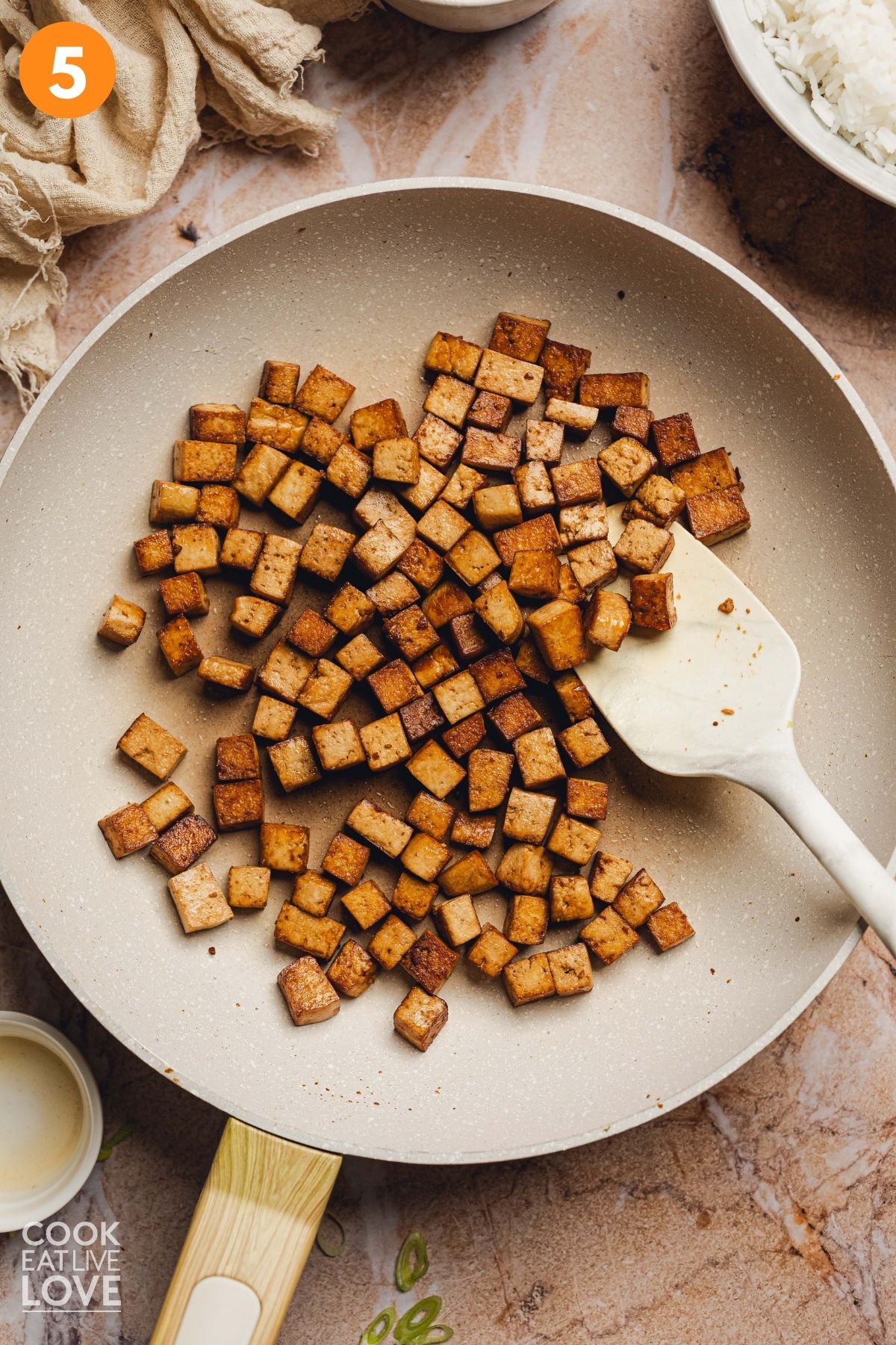 The cubes of tofu cooking in the skillet.