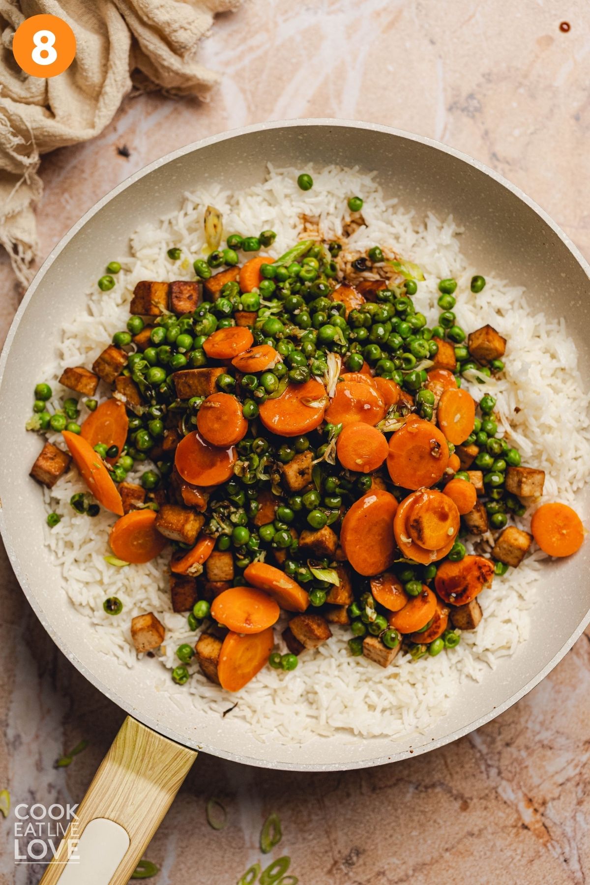 The fried rice being combined with all of the ingredients to cook.