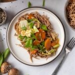 A plate with Cabbage, snap peas, bell peppers and stir-fried noodles.