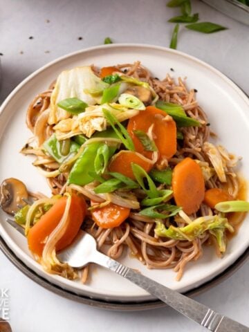 A fork picking up some chop suey with vegetables.