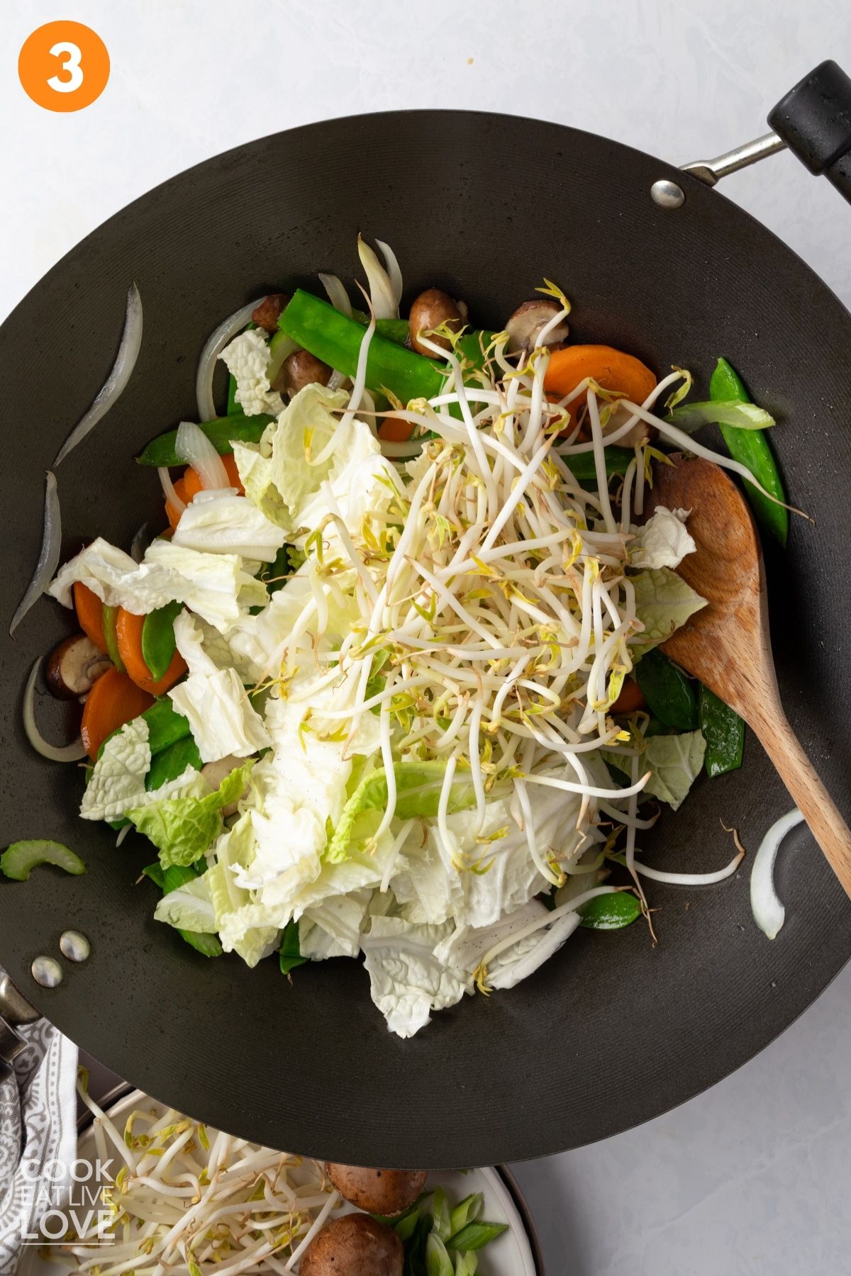 Bok choy, bean sprouts, garlic, and ginger added to the wok.