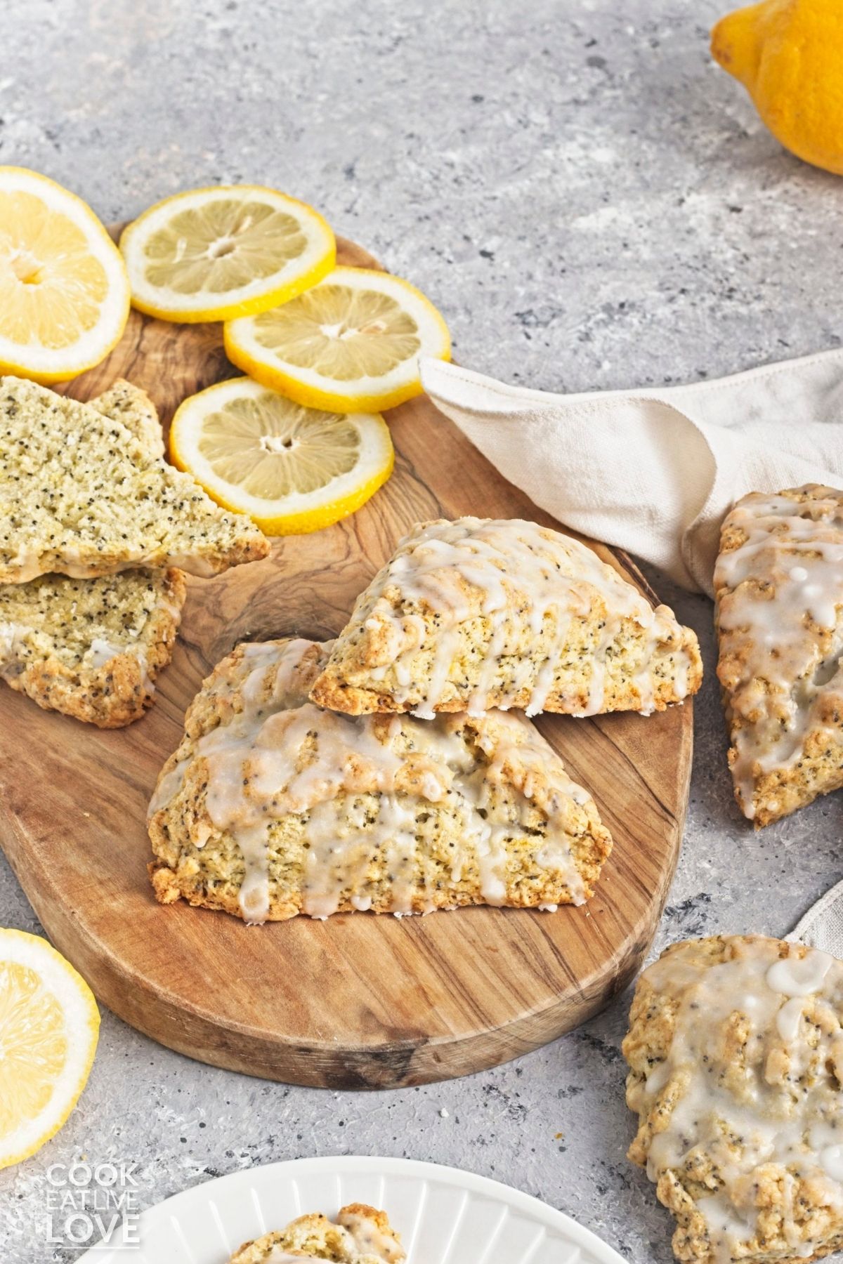 Poppyseed scones stacked on top of one another on a cutting board.