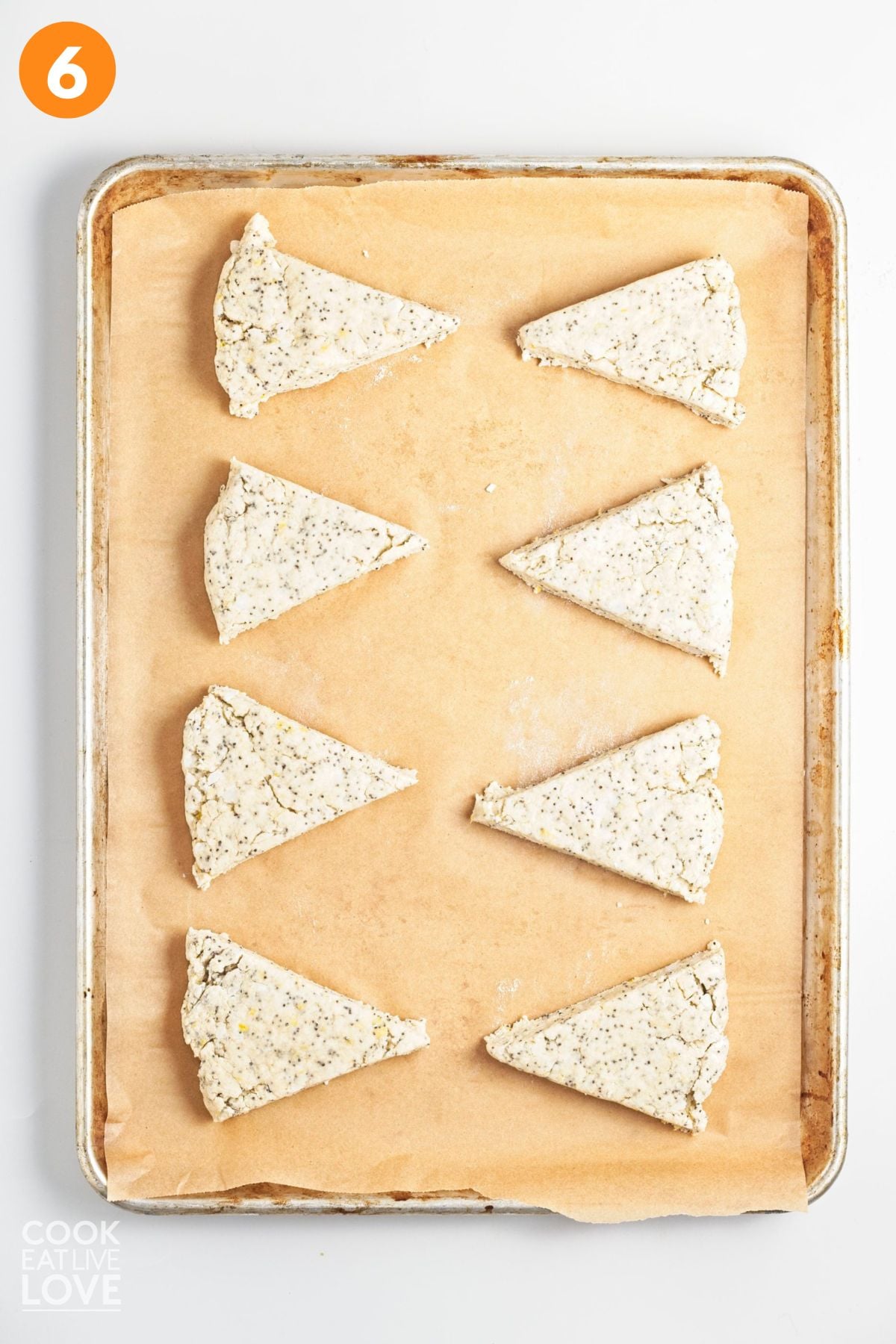 Lemon scones cut and on a baking tray lined with parchment. 
