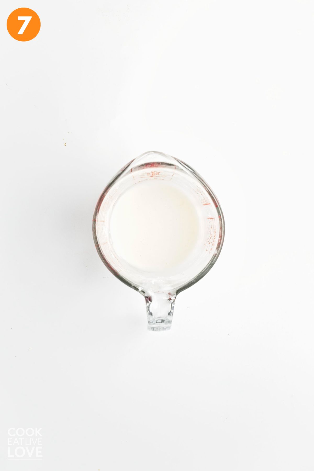 Glaze for lemon poppyseed scones in a liquid measuring cup. 