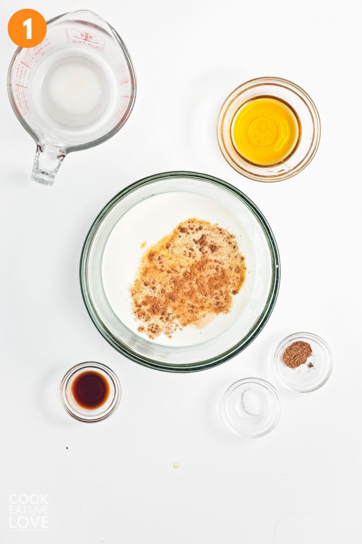 Oat milk, maple syrup, vanilla extract, salt, and nutmeg being added to a bowl.