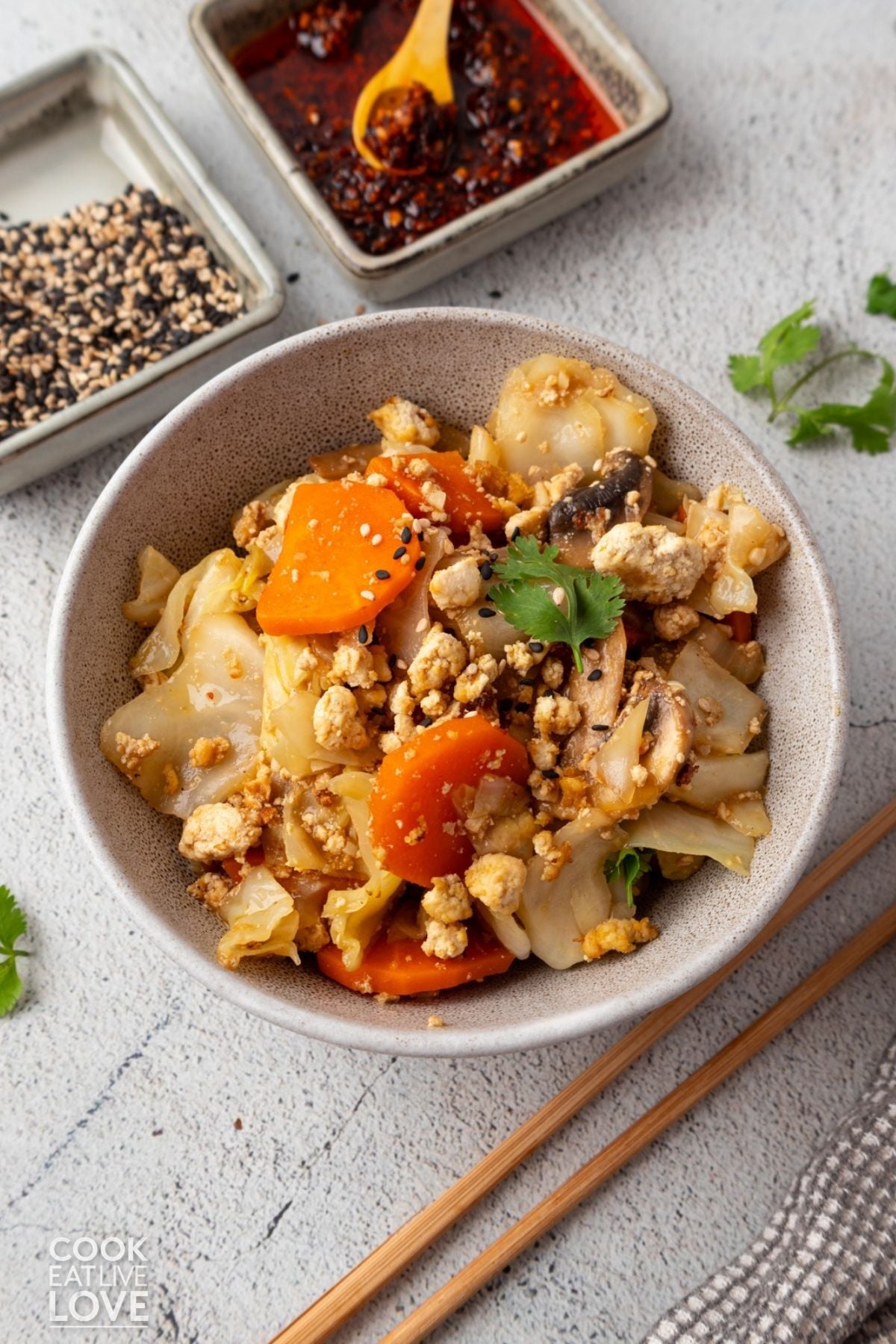 A bowl filled with stir fry with cabbage and tofu.