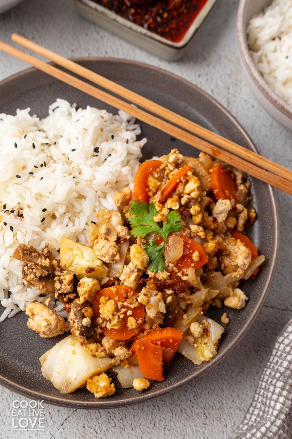 Tofu cabbage stir fry on a plate with chopsticks on the side.