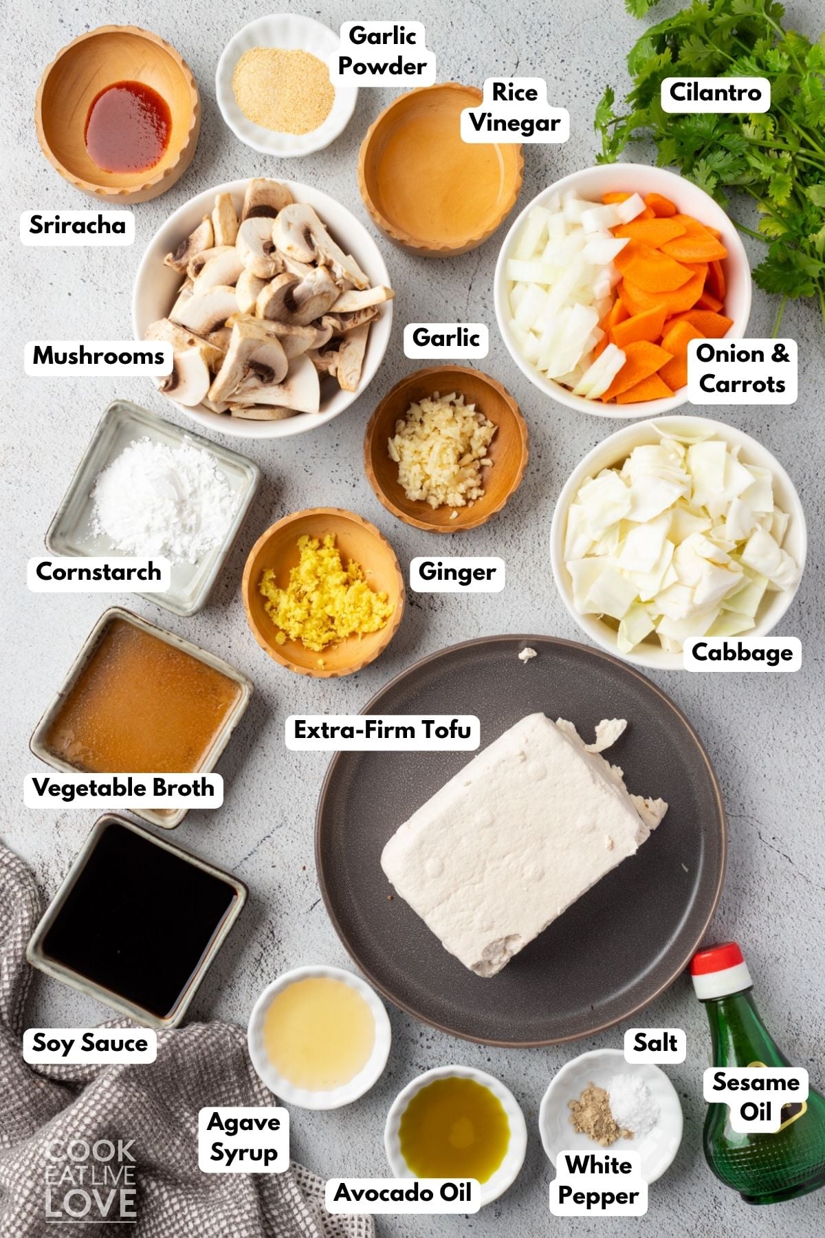 Ingredients to make this cabbage and tofu stir fry in bowls on a table.