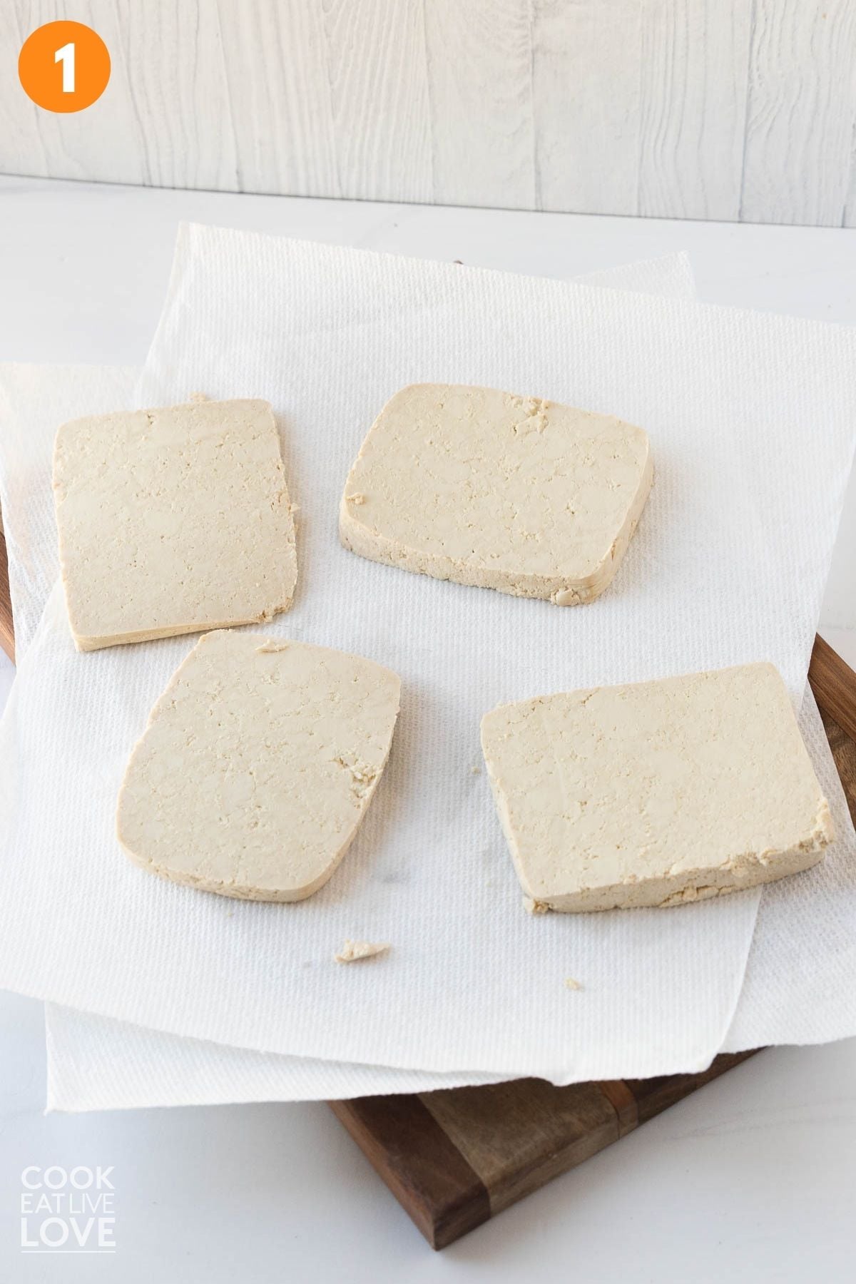 Slices of tofu on paper towels.