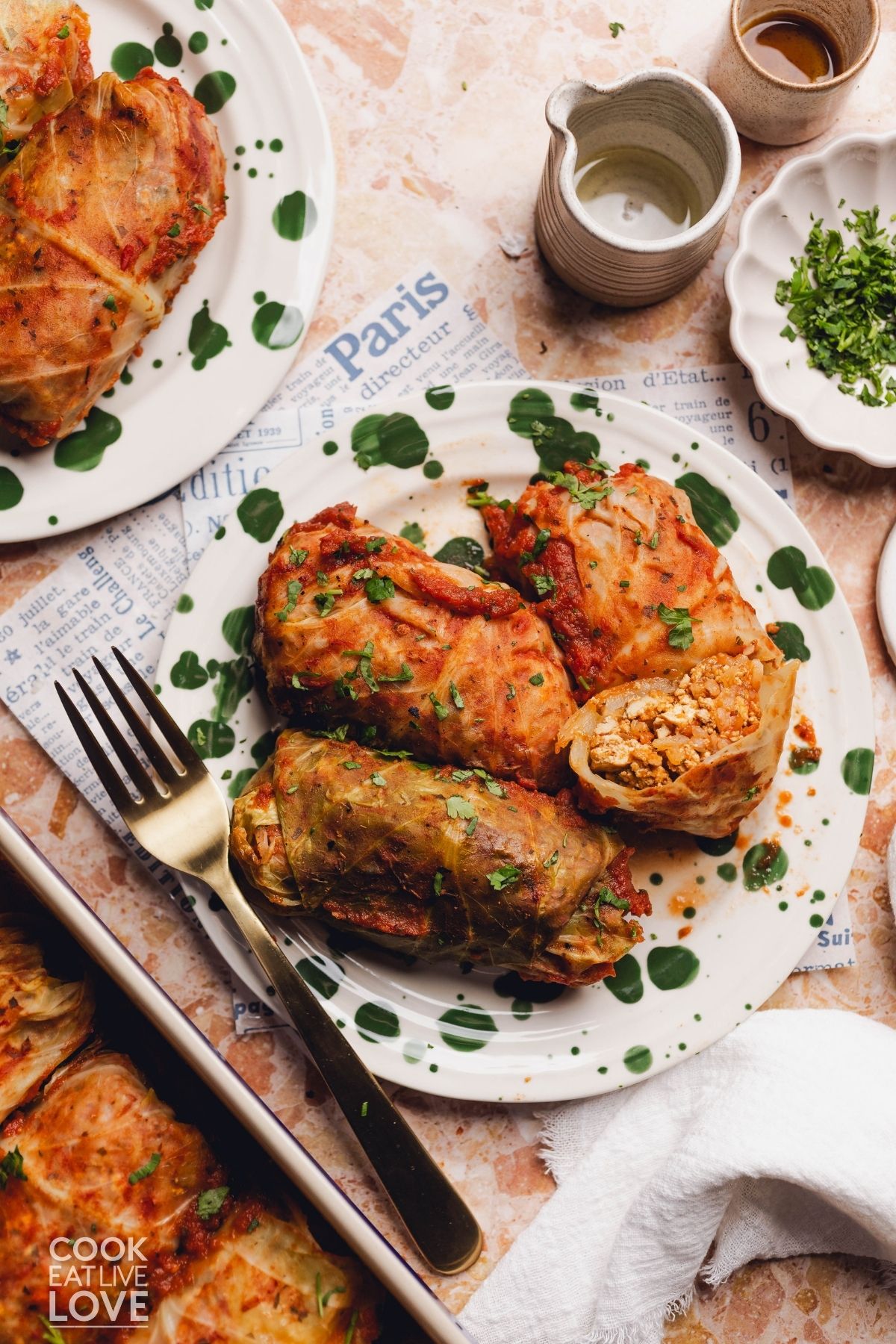 Vegetarian cabbage rolls on a plate with a fork on the side.