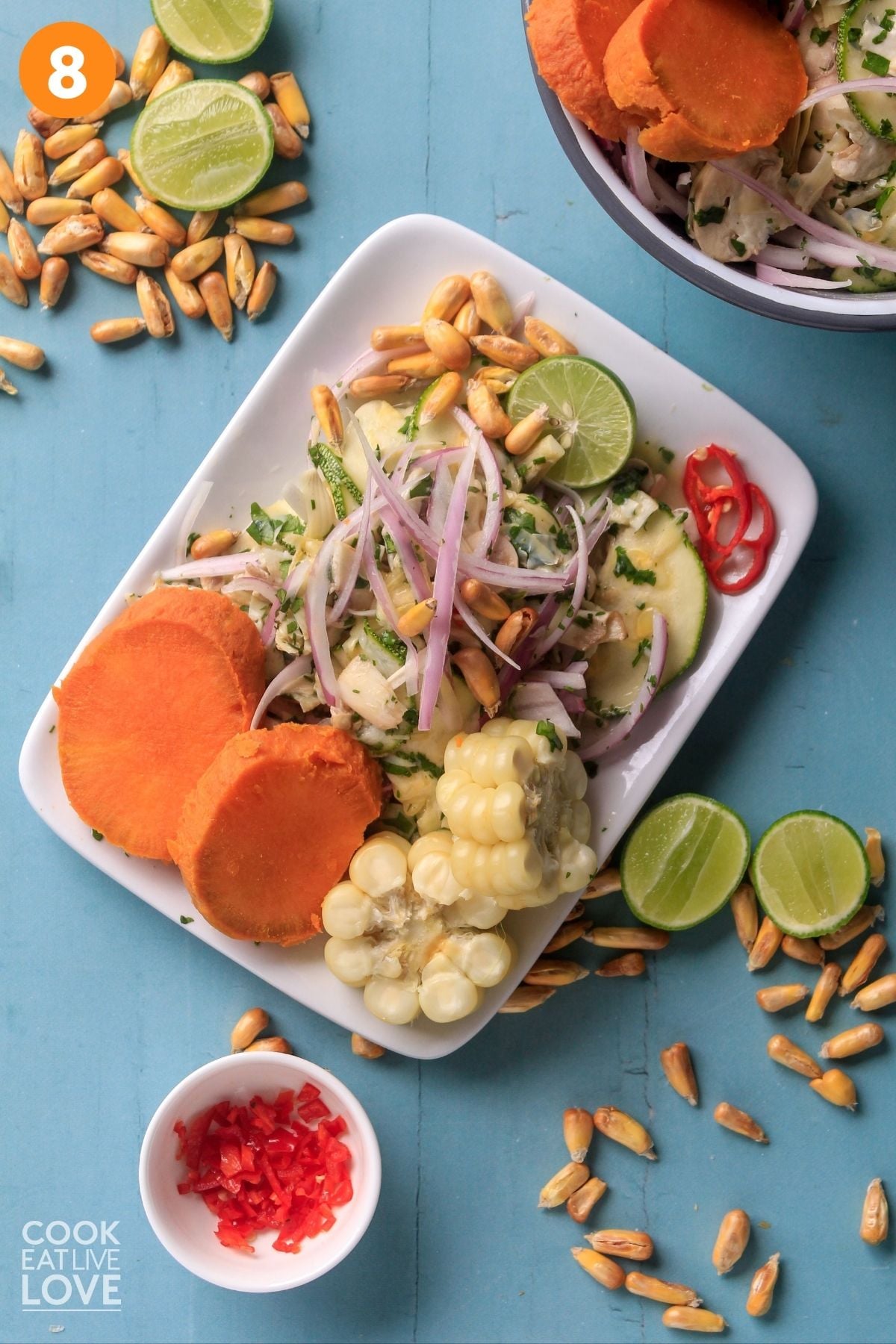 Peruvian ceviche on a plate garnished with cooked sweet potatoes and corn. 