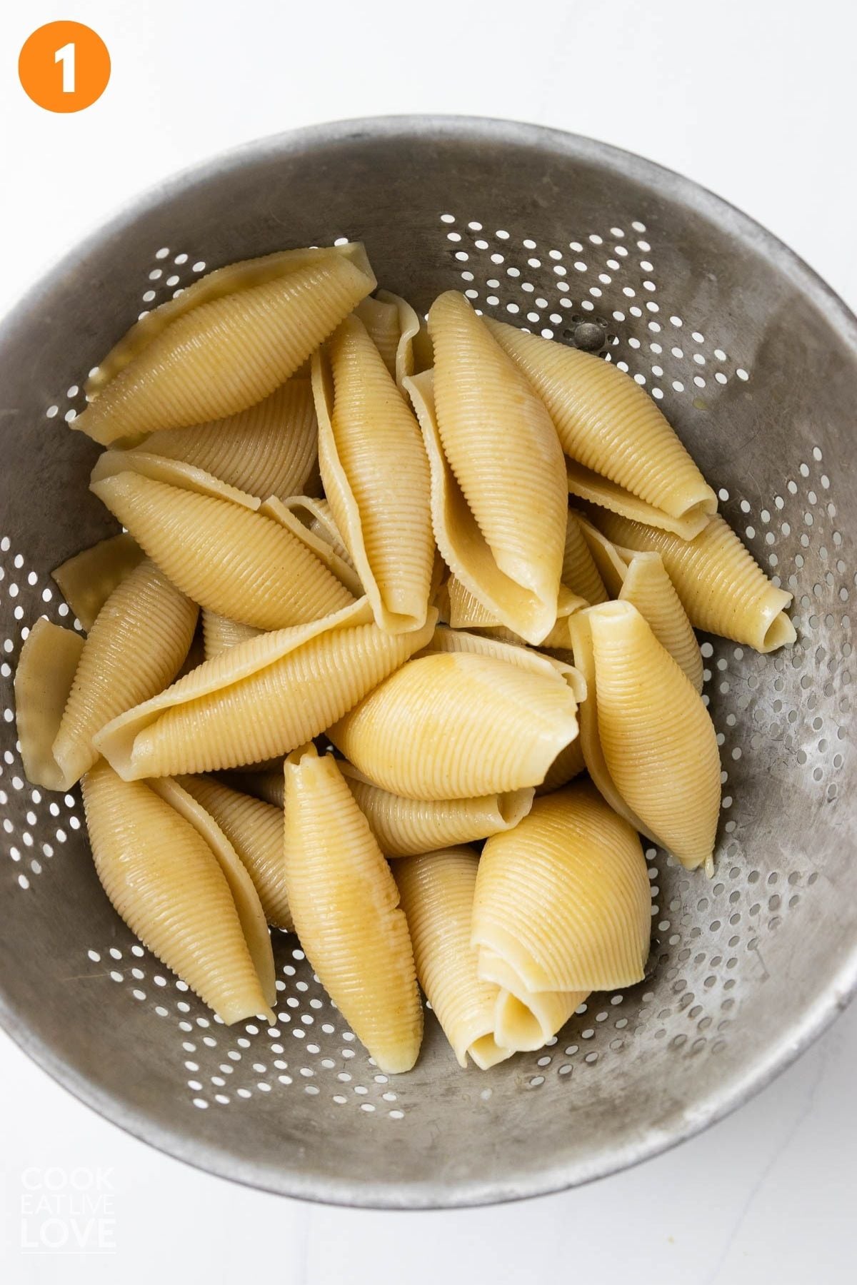 Cooked shells in a strainer. 