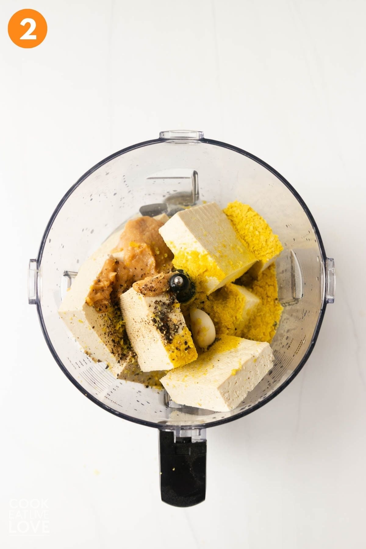 Tofu and vegan ricotta ingredients added to a food processor.