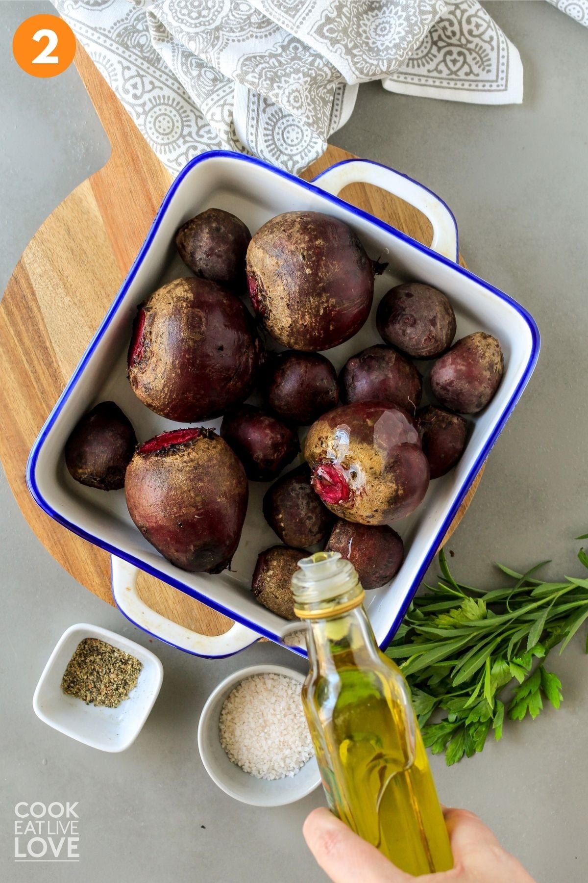 Beets in a roasting dish and olive oil drizzling on top