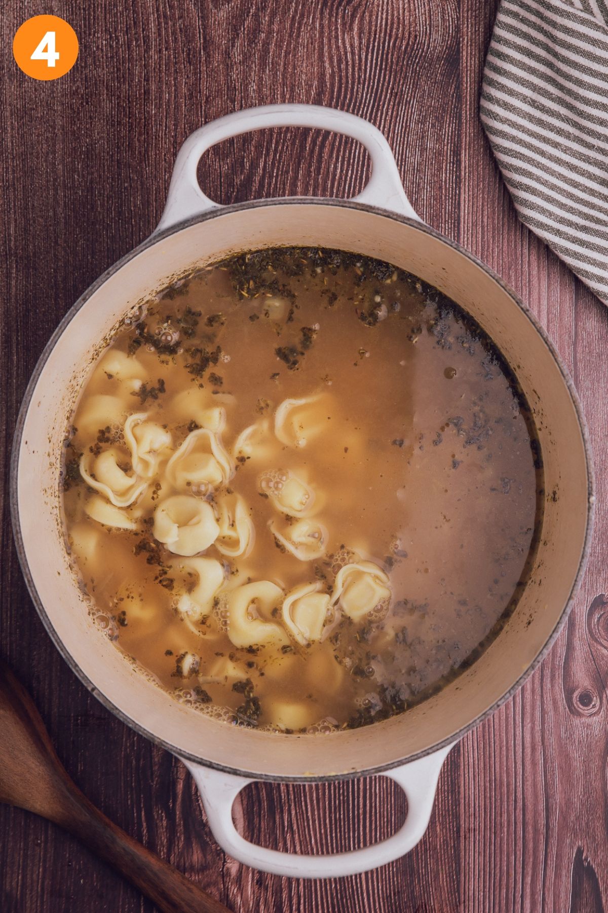 Tortellini added to the pot of broth to cook.