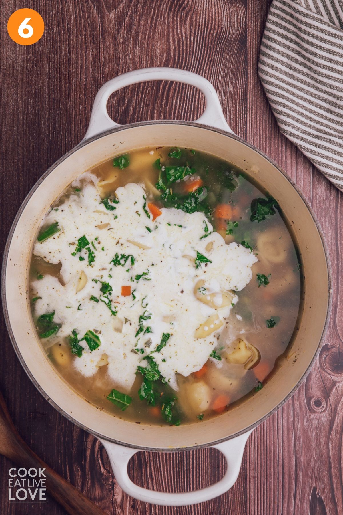 Adding the heavy cream to the pot of tortellini soup.